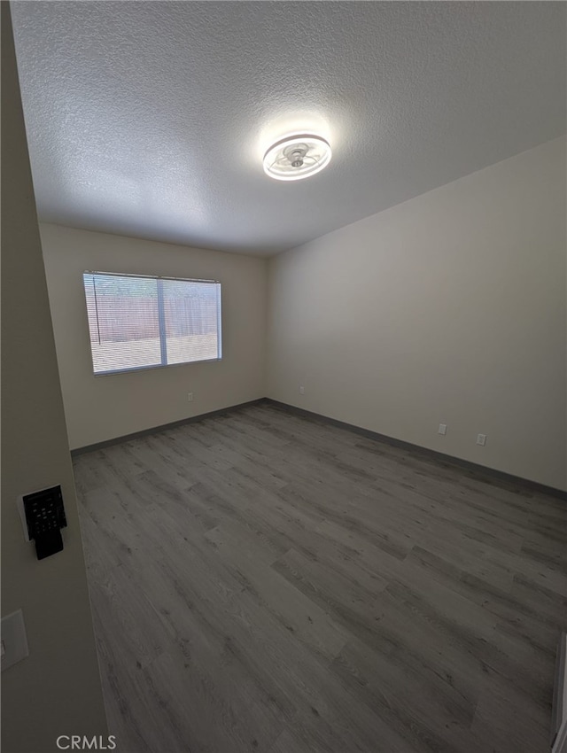 10736 Dove Ct, Adelanto, CA 92301 - spare room featuring wood finished floors, a textured ceiling, and baseboards