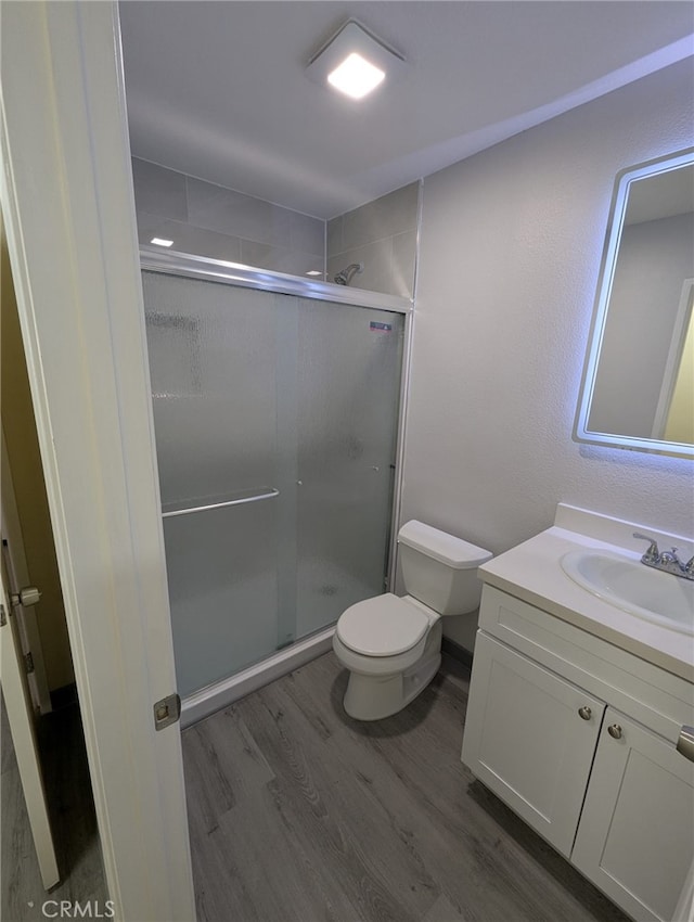 10736 Dove Ct, Adelanto, CA 92301 - full bath featuring wood finished floors, a shower stall, toilet, and vanity