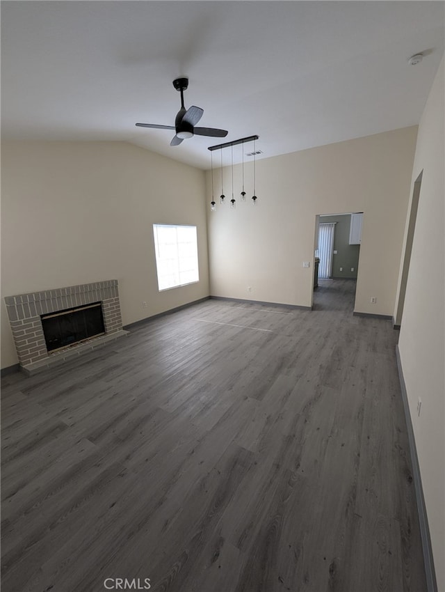 10736 Dove Ct, Adelanto, CA 92301 - unfurnished living room with wood finished floors, a ceiling fan, vaulted ceiling, a fireplace, and baseboards