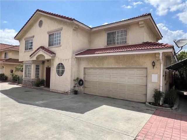 mediterranean / spanish-style house with stucco siding, concrete driveway, an attached garage, and a tiled roof