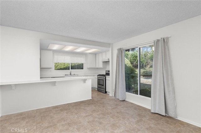 46 Los Palos Dr, San Luis Obispo, CA 93401 - kitchen with gas stove, a sink, a peninsula, light countertops, and healthy amount of natural light
