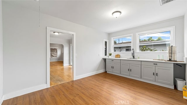 unfurnished dining area with baseboards, light wood-style floors, and a sink