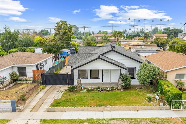 ranch-style home featuring a gate, a shingled roof, concrete driveway, and a residential view