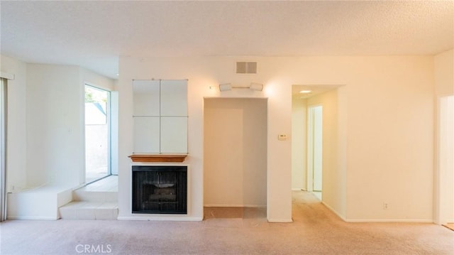 unfurnished living room featuring light carpet, a fireplace, and baseboards