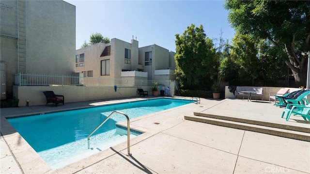 community pool featuring a patio area and fence