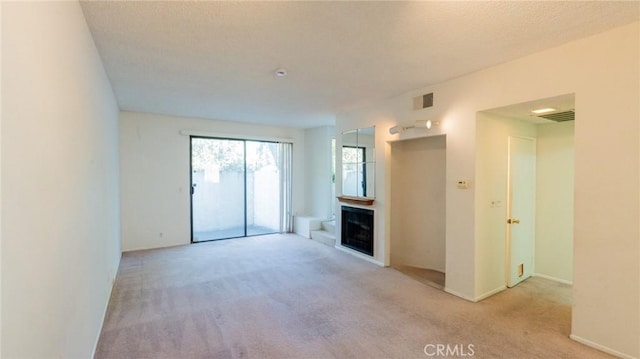 unfurnished living room with carpet flooring, a fireplace, and baseboards