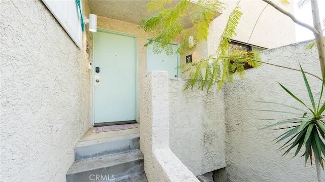 view of exterior entry with stucco siding