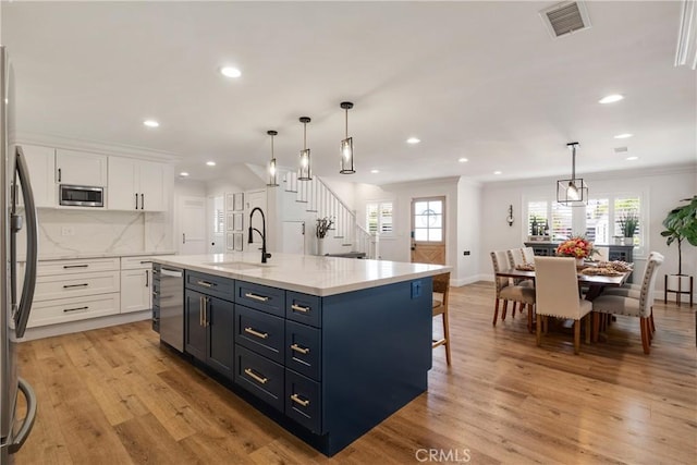 2090 Tevis Ave, Long Beach, CA 90815 - kitchen with a sink, white cabinets, stainless steel appliances, light wood-style flooring, and recessed lighting