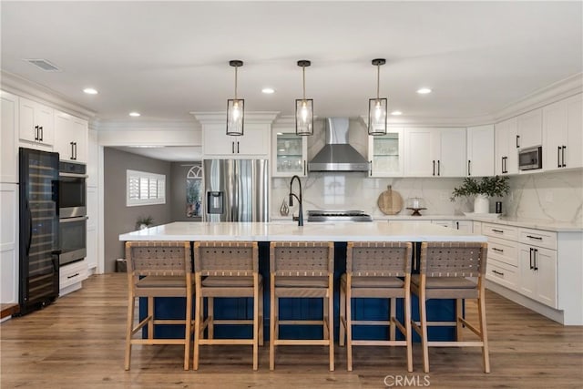 2090 Tevis Ave, Long Beach, CA 90815 - kitchen with stainless steel appliances, wall chimney range hood, light countertops, white cabinetry, and backsplash