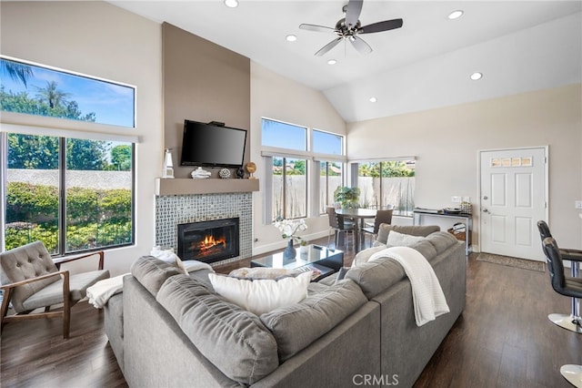 living room featuring high vaulted ceiling, a tiled fireplace, recessed lighting, dark wood-style flooring, and a ceiling fan