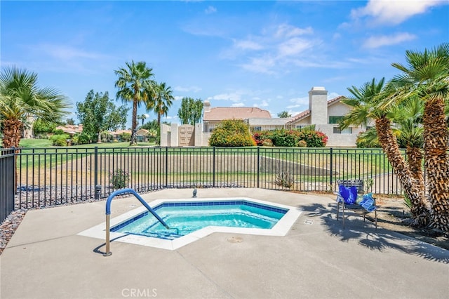 view of pool with a hot tub and fence