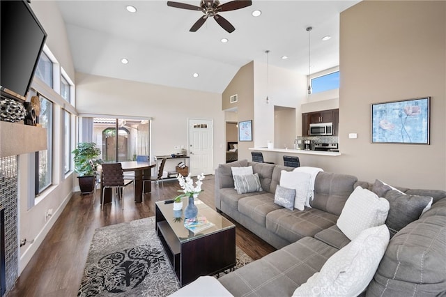 living room featuring high vaulted ceiling, ceiling fan, plenty of natural light, dark wood-type flooring, and recessed lighting