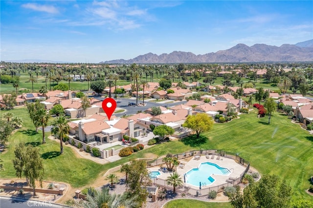 aerial overview of property's location with a pool area, nearby suburban area, and mountains