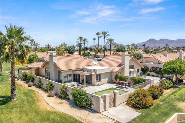 back of house with stucco siding, a tiled roof, a patio, and a mountain view