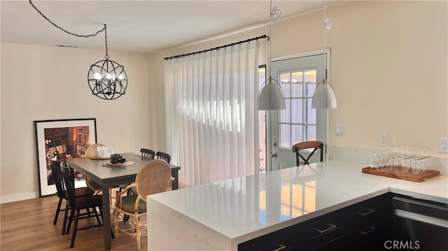 7140 N Muscatel Ave, San Gabriel, CA 91775 - kitchen featuring dark cabinets, wood finished floors, a chandelier, a peninsula, and pendant lighting