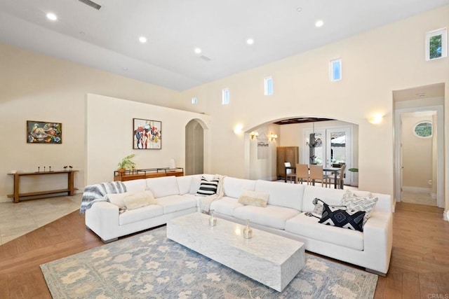 1455 Independence Way, Vista, CA 92084 - living room featuring arched walkways, a high ceiling, baseboards, recessed lighting, and wood finished floors