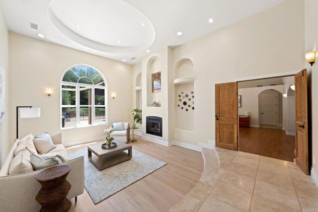 1455 Independence Way, Vista, CA 92084 - living area featuring recessed lighting, built in shelves, a towering ceiling, a glass covered fireplace, and light wood finished floors