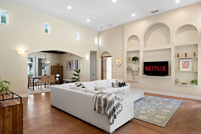 1455 Independence Way, Vista, CA 92084 - living area with arched walkways, healthy amount of natural light, wood finished floors, built in features, and recessed lighting