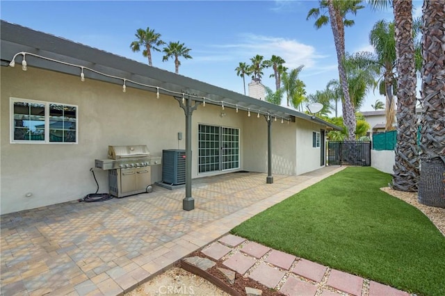 rear view of property featuring stucco siding, a chimney, and a patio
