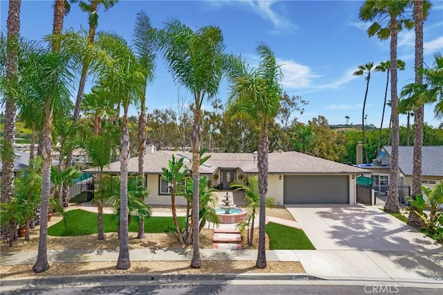 view of front of house featuring driveway, a garage, fence, and stucco siding