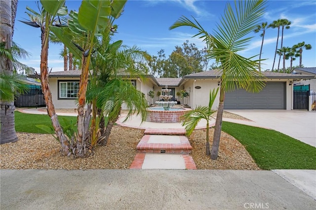 ranch-style house with an attached garage, stucco siding, fence, and driveway