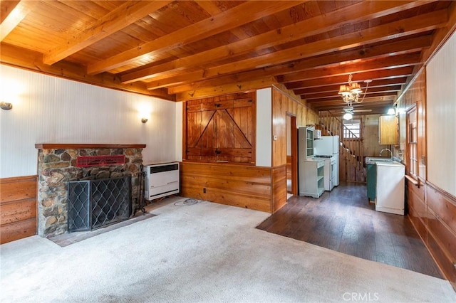 26370 Alpine Ln, Twin Peaks, CA 92391 - living room featuring heating unit, beam ceiling, wooden walls, dark wood-style floors, and dark colored carpet