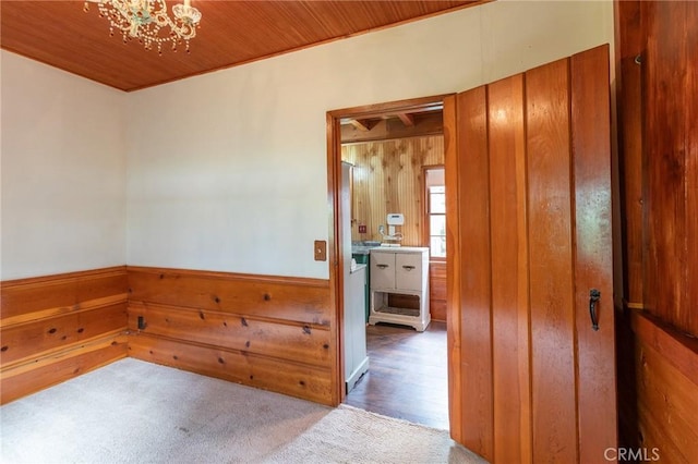 26370 Alpine Ln, Twin Peaks, CA 92391 - carpeted empty room with wooden walls, a chandelier, wood ceiling, and a wainscoted wall