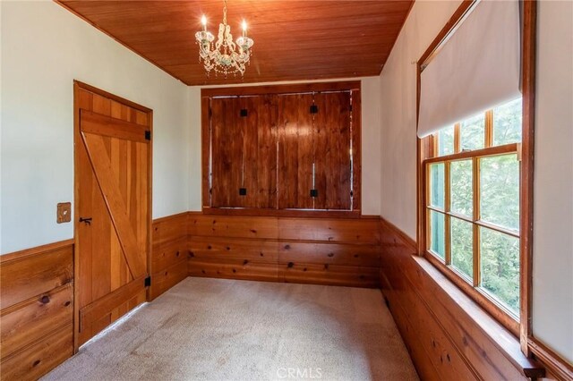 26370 Alpine Ln, Twin Peaks, CA 92391 - carpeted spare room with healthy amount of natural light, wooden ceiling, wooden walls, a chandelier, and a wainscoted wall