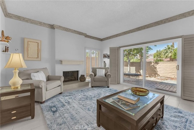 living area with a textured ceiling, a fireplace with raised hearth, and light tile patterned floors