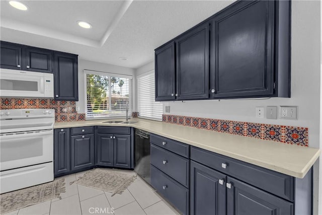 kitchen with white appliances, a sink, light countertops, and recessed lighting