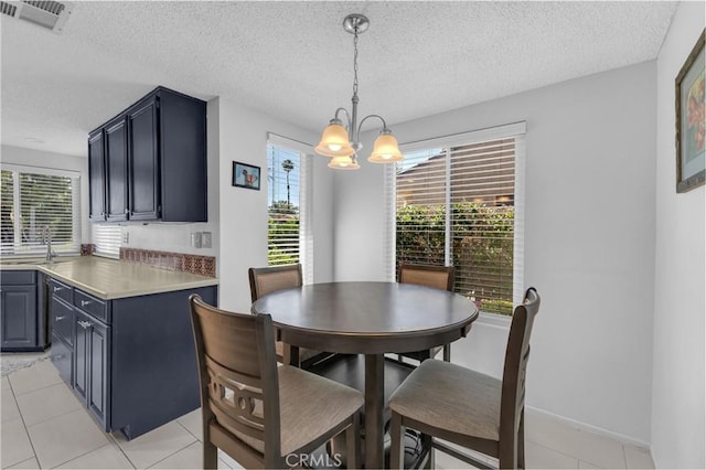 dining space featuring a chandelier, a textured ceiling, light tile patterned floors, and baseboards