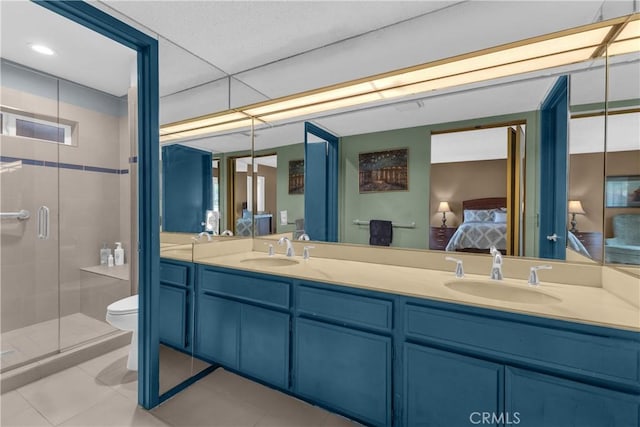 full bath with ensuite bathroom, double vanity, tile patterned flooring, a shower stall, and toilet