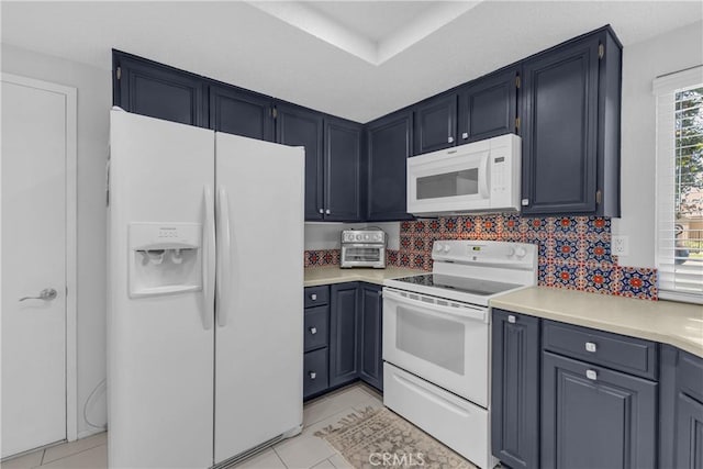 kitchen featuring white appliances, light countertops, light tile patterned flooring, and blue cabinets