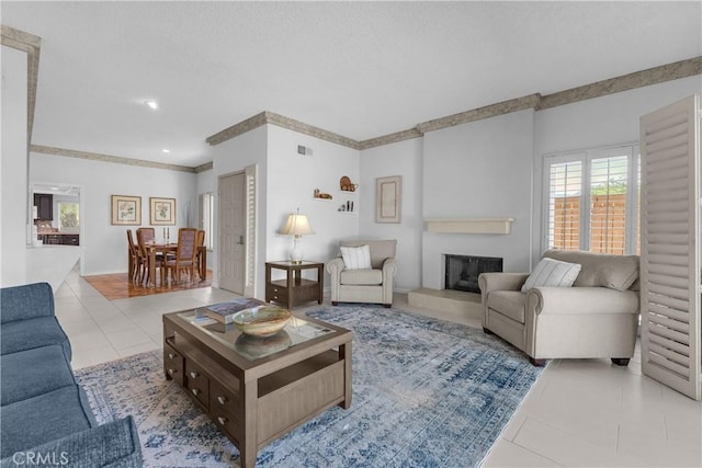 tiled living room with plenty of natural light and a fireplace with raised hearth