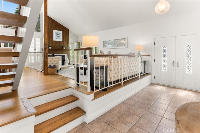 23721 Sarda Rd, Valencia, CA 91355 - tiled foyer entrance with healthy amount of natural light, a large fireplace, high vaulted ceiling, and stairs