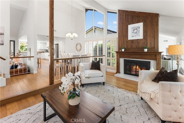 23721 Sarda Rd, Valencia, CA 91355 - living area featuring high vaulted ceiling, hardwood / wood-style floors, a glass covered fireplace, and a chandelier