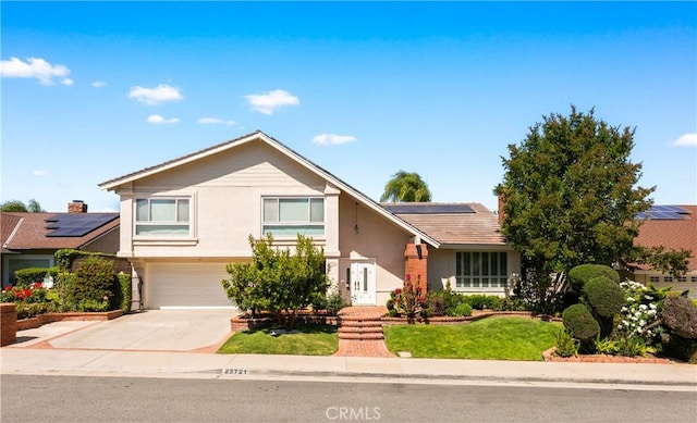 23721 Sarda Rd, Valencia, CA 91355 - view of front of home with roof mounted solar panels, a garage, concrete driveway, stucco siding, and a front lawn