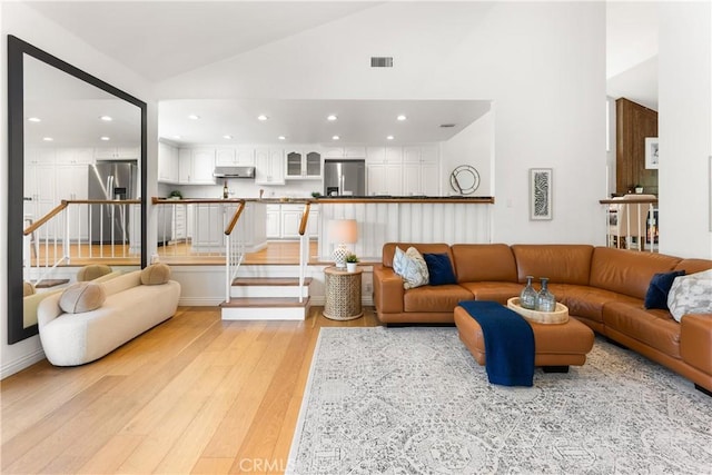 23721 Sarda Rd, Valencia, CA 91355 - living room with light wood finished floors, recessed lighting, high vaulted ceiling, and stairs