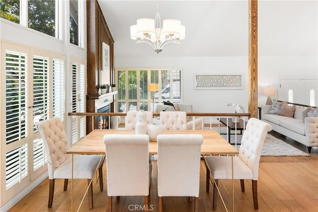 23721 Sarda Rd, Valencia, CA 91355 - dining space with a chandelier, wood finished floors, and a high ceiling