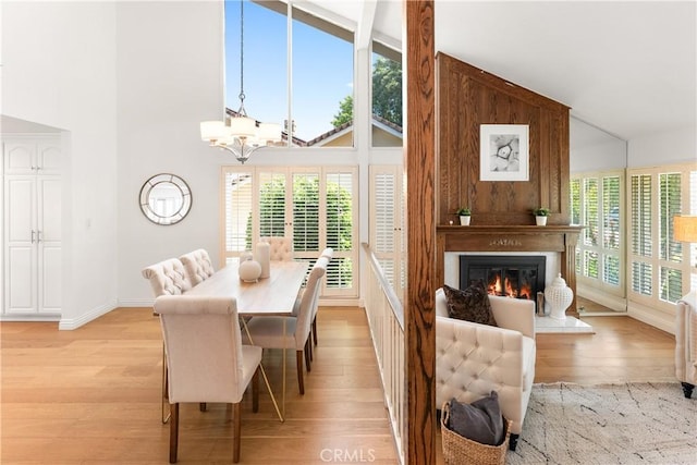 23721 Sarda Rd, Valencia, CA 91355 - dining space with a chandelier, high vaulted ceiling, light wood-style flooring, and a fireplace