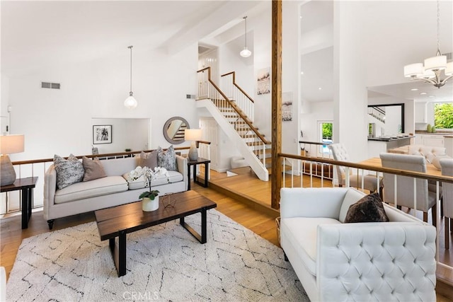 23721 Sarda Rd, Valencia, CA 91355 - living area featuring high vaulted ceiling, stairway, a chandelier, wood finished floors, and beam ceiling