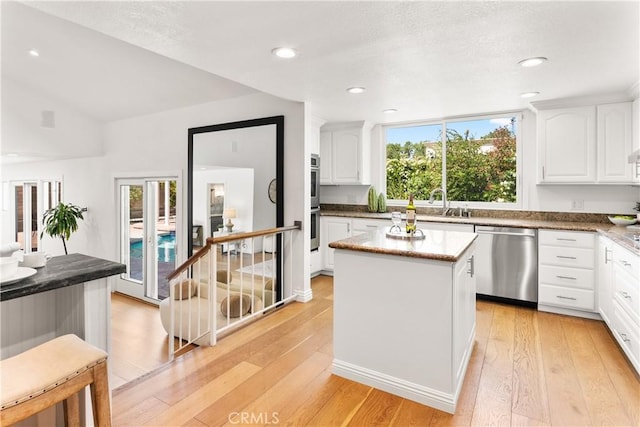 23721 Sarda Rd, Valencia, CA 91355 - kitchen featuring stainless steel appliances, light wood-style floors, white cabinets, a kitchen island, and recessed lighting