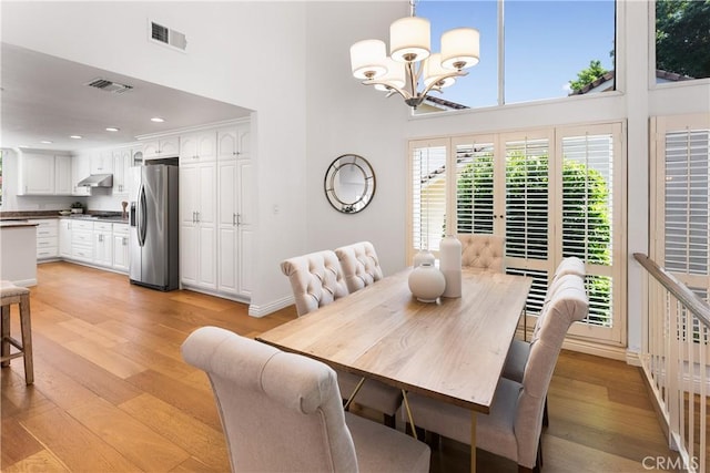 23721 Sarda Rd, Valencia, CA 91355 - dining area featuring a towering ceiling, a chandelier, light wood-style flooring, and recessed lighting