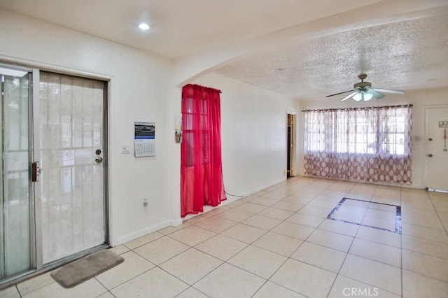 2851 Webster Ave, Long Beach, CA 90810 - entrance foyer with light tile patterned floors, ceiling fan, arched walkways, baseboards, and a textured ceiling