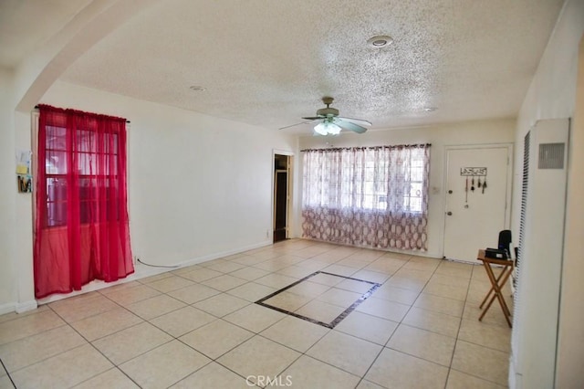 2851 Webster Ave, Long Beach, CA 90810 - tiled spare room with ceiling fan, a textured ceiling, arched walkways, and a heating unit