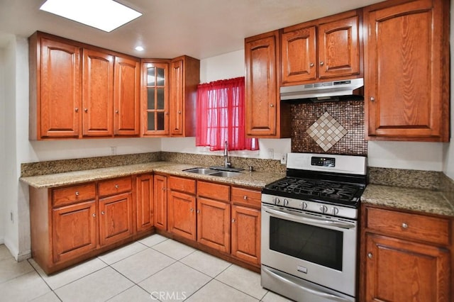 2851 Webster Ave, Long Beach, CA 90810 - kitchen with stainless steel gas range, under cabinet range hood, brown cabinets, and recessed lighting
