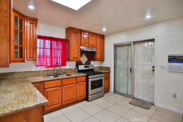 2851 Webster Ave, Long Beach, CA 90810 - kitchen featuring stainless steel range with gas cooktop, under cabinet range hood, a sink, glass insert cabinets, and brown cabinets