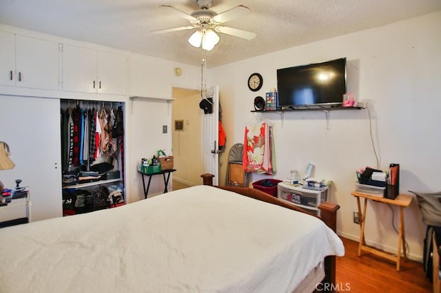 2851 Webster Ave, Long Beach, CA 90810 - bedroom with wood finished floors, a closet, a textured ceiling, ceiling fan, and baseboards