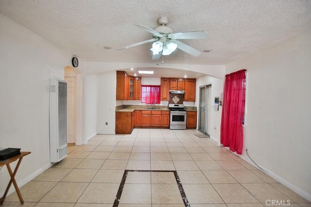 2851 Webster Ave, Long Beach, CA 90810 - kitchen with stainless steel range oven, a heating unit, a sink, brown cabinets, and ceiling fan