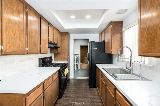 25176 Wendy Way, Moreno Valley, CA 92551 - kitchen featuring black appliances, a raised ceiling, a sink, dark wood-type flooring, and brown cabinets